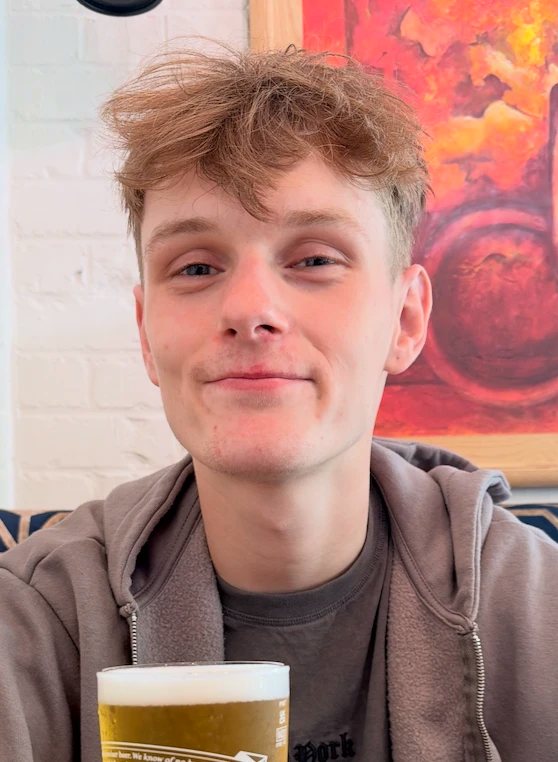 Kieran, vape-free, holding a pint and looking smug
